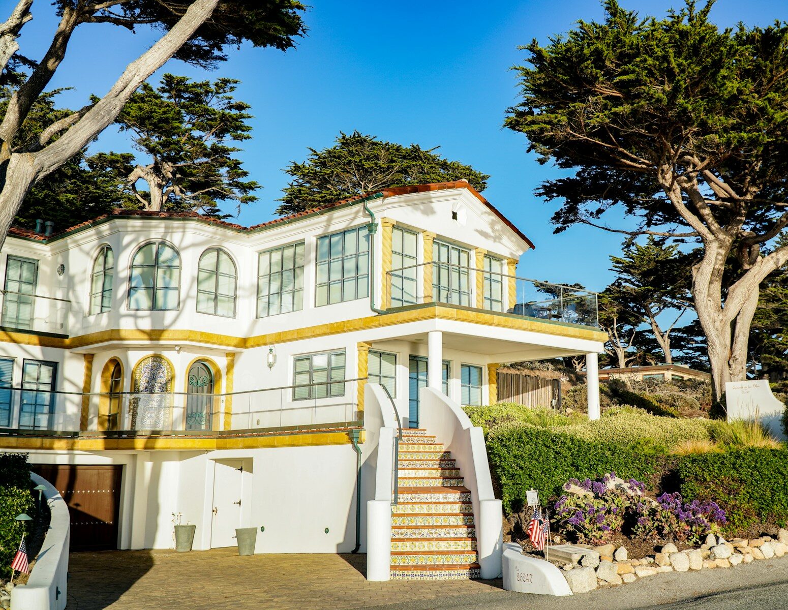 a large white house with trees and bushes around it